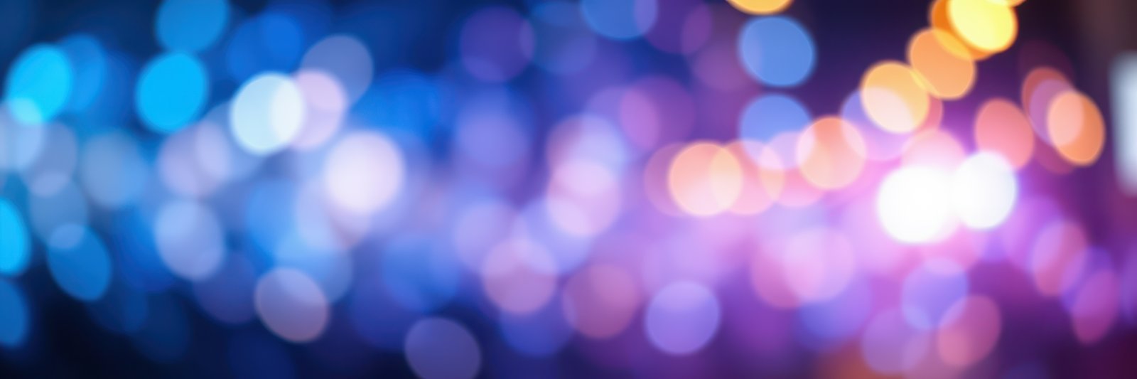 Colorful bokeh lights create a dreamy atmosphere during a nighttime celebration in a vibrant city